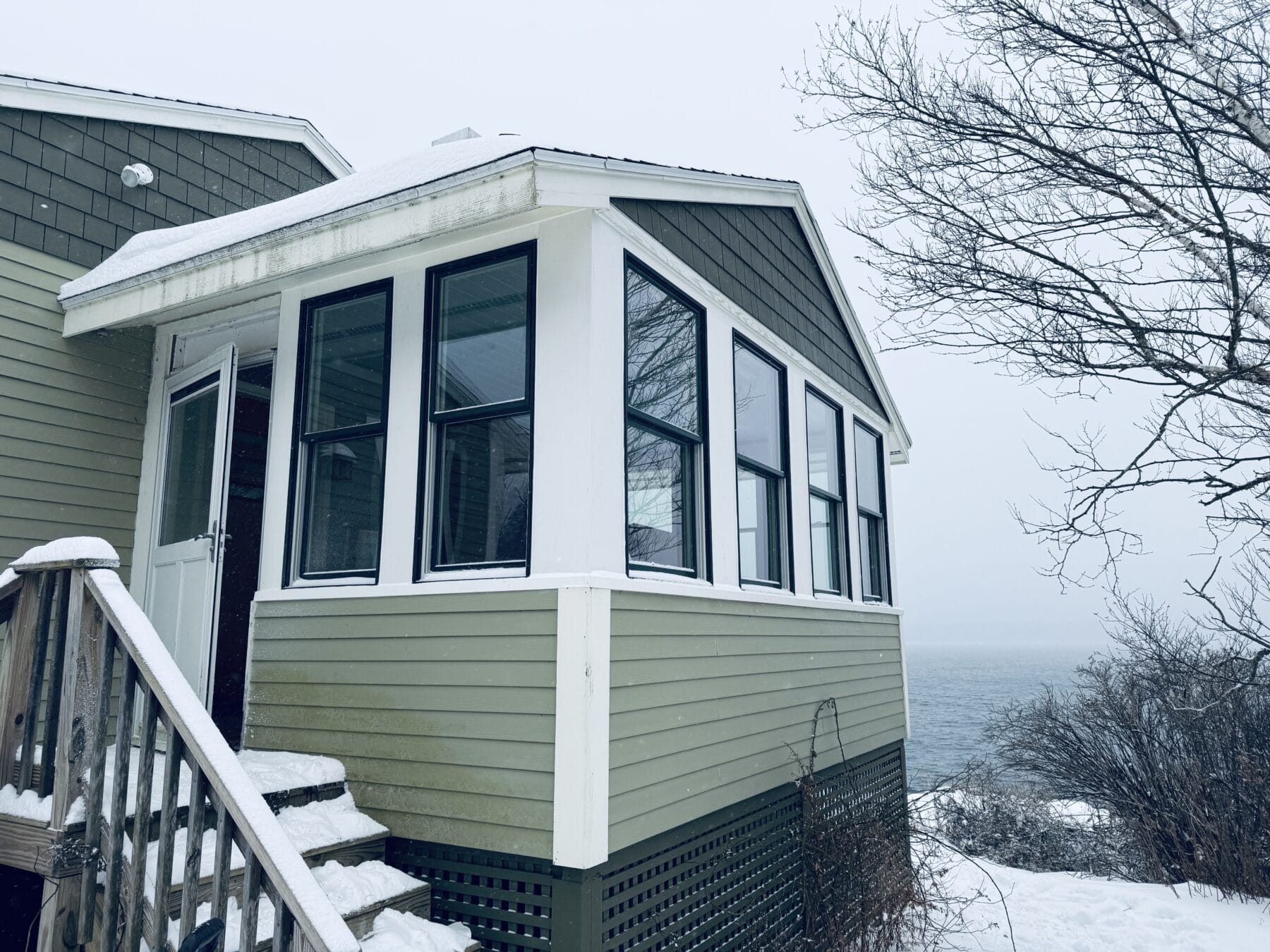 Double-hung windows installed by Best Choice Windows & Doors on Peaks Island in Maine, ocean in the background.