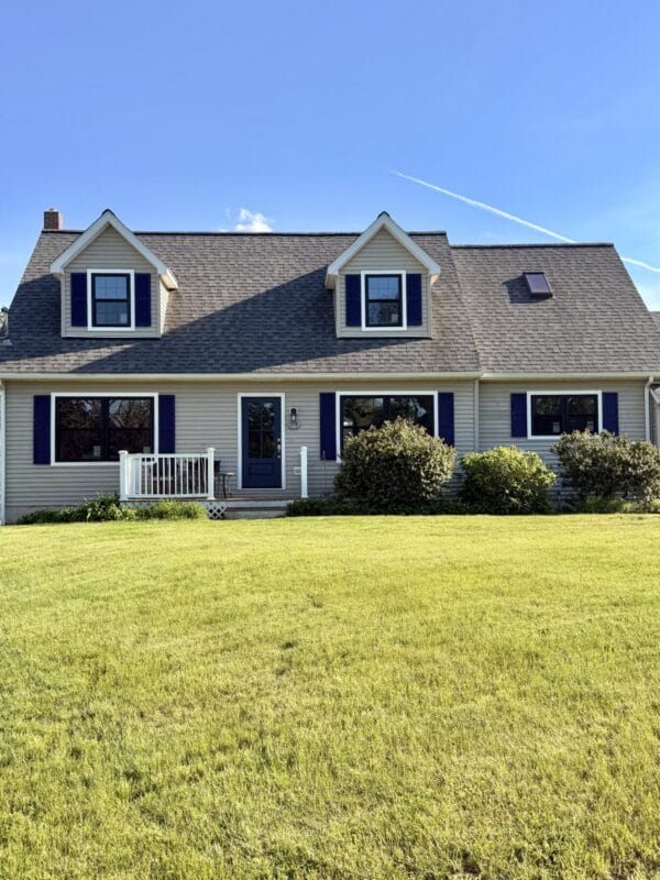 Modern farmhouse home exterior featuring black ProVia Endure replacement windows with colonial grids and white trim in Dover, New Hampshire