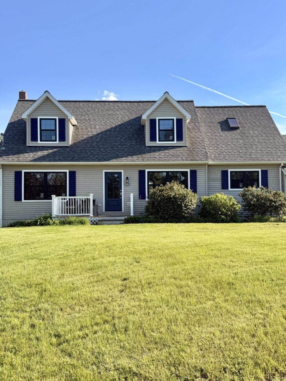 Modern farmhouse home exterior featuring black ProVia Endure replacement windows with colonial grids and white trim in Dover, New Hampshire